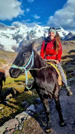 Traveler riding a horse during the Ausangate Horseback Trek with glaciers in the background