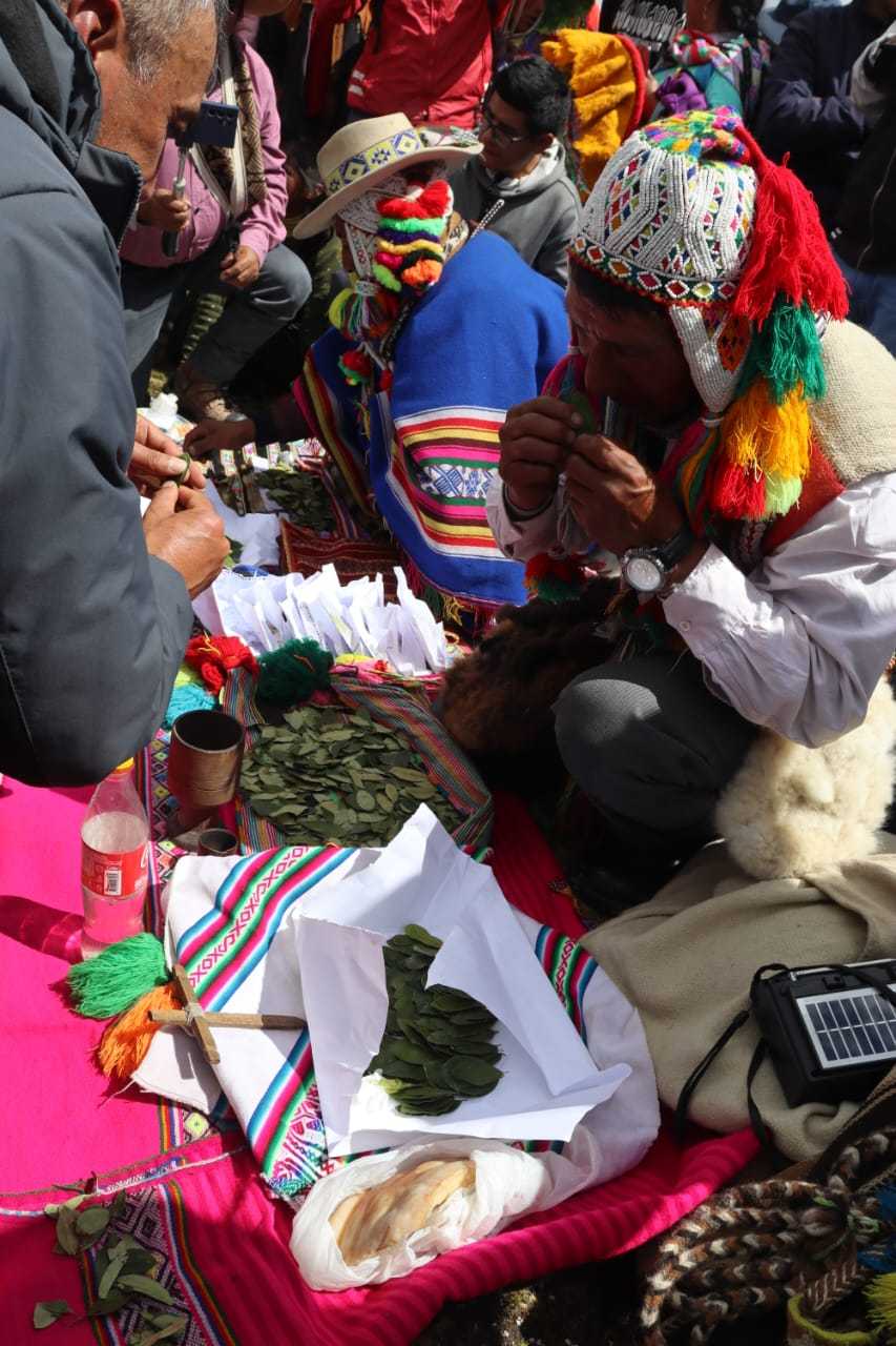 Ritual ancestral de Pago a la Tierra en los Andes, con chamanes y ofrendas de flores, chicha y semillas para la Pachamama
